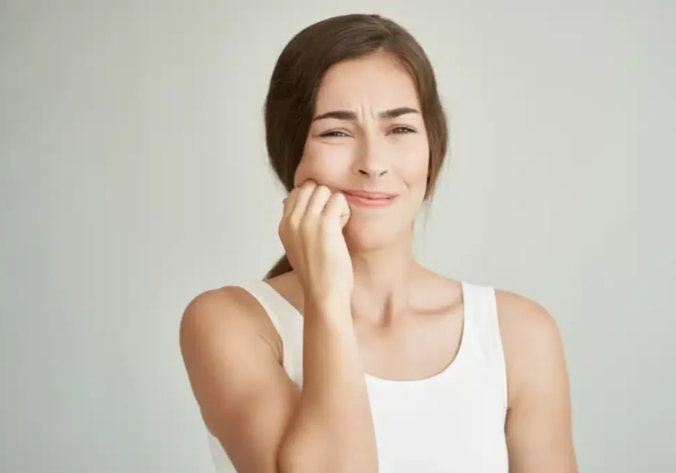img-perfect-smiles-orthodontics-emergencies-banner Woman with hand to face experiencing tooth pain or discomfort, white background.